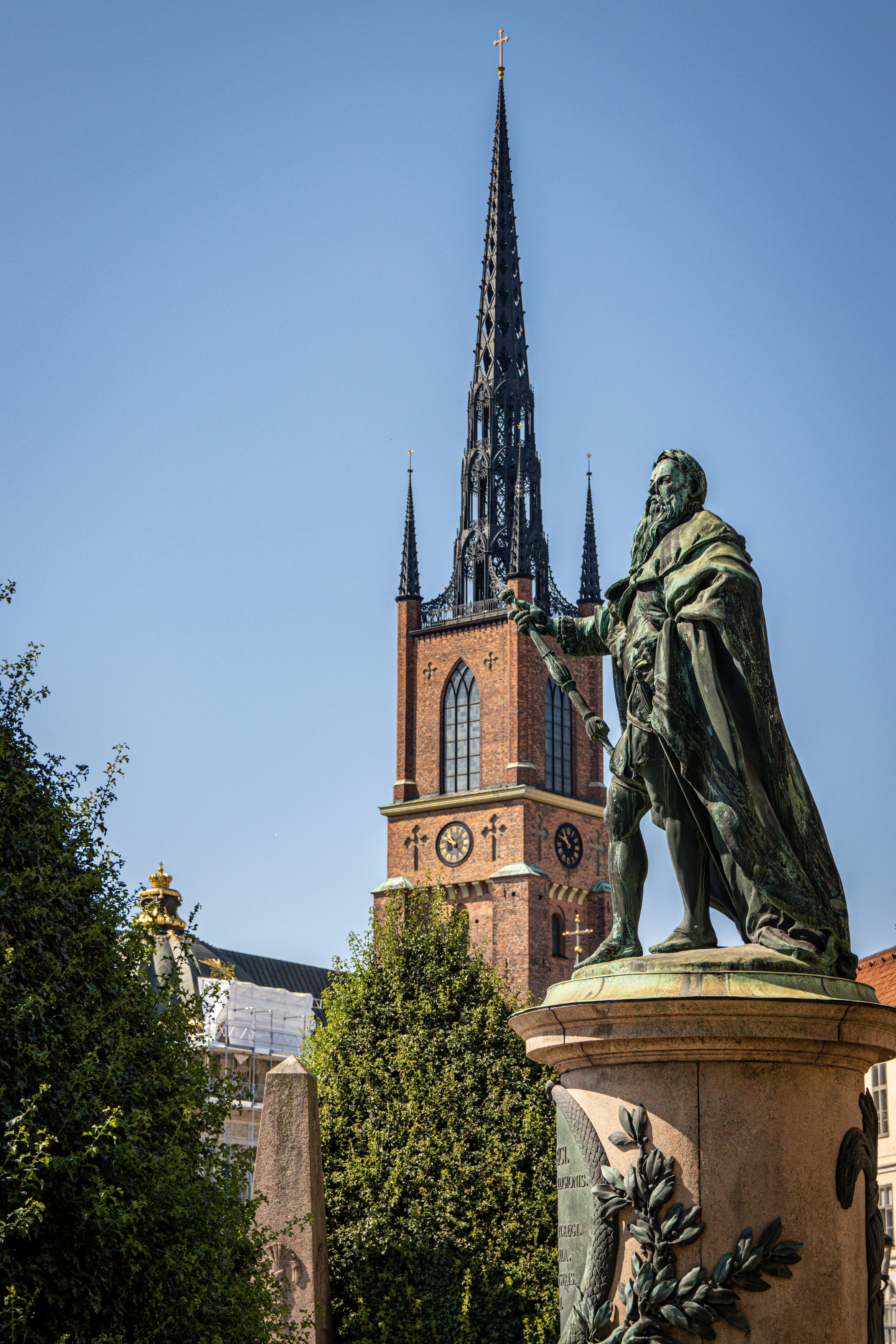 A striking view of a statue near the iconic Riddarholmen Church in Stockholm, Sweden.