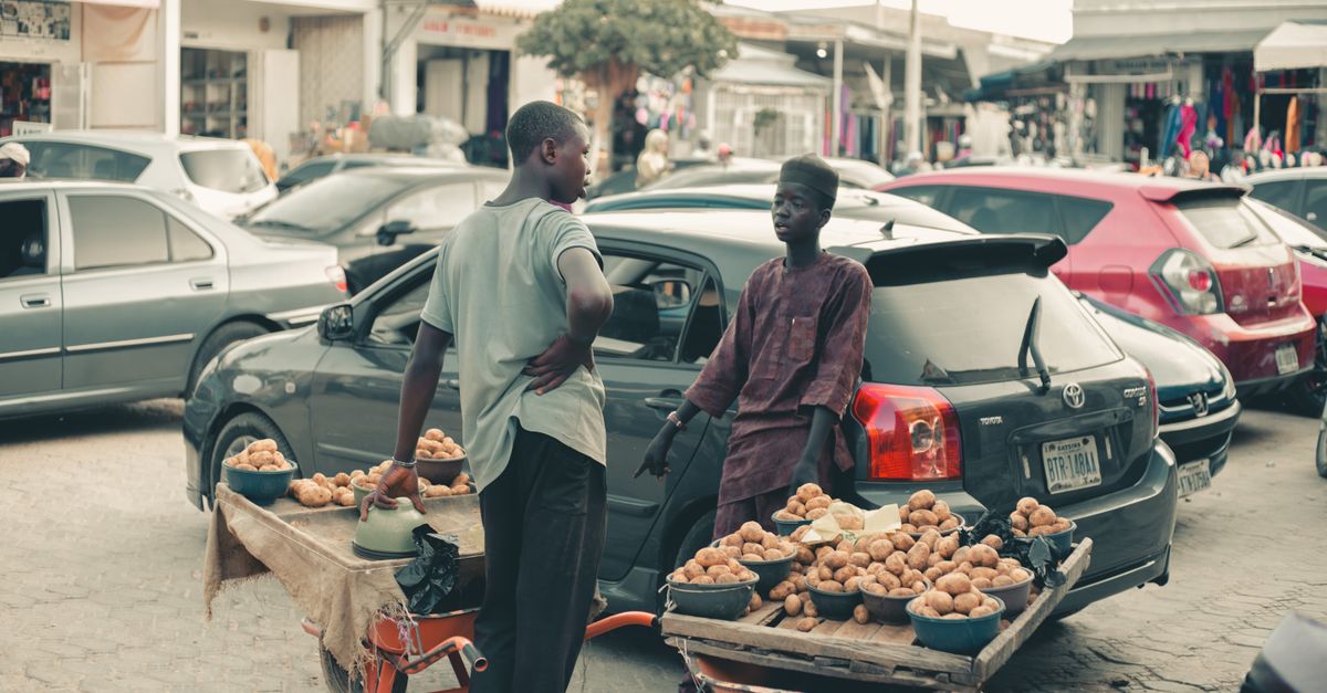 local vendor using mobile money terminal at a market stall near Christ Embassy Loveworld Arena