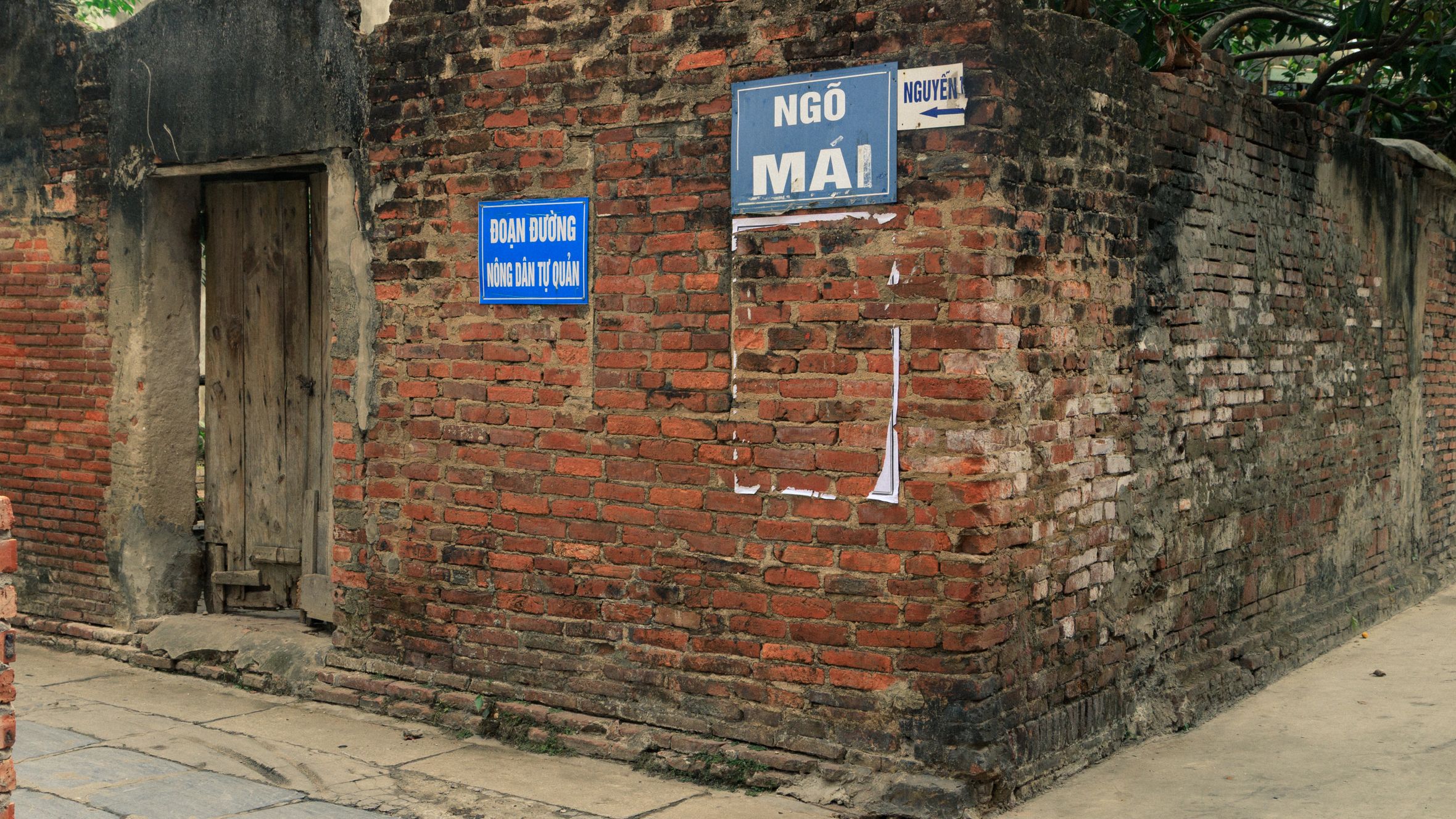 Explore the rustic charm of an old brick wall in Bắc Ninh, decorated with flags.
