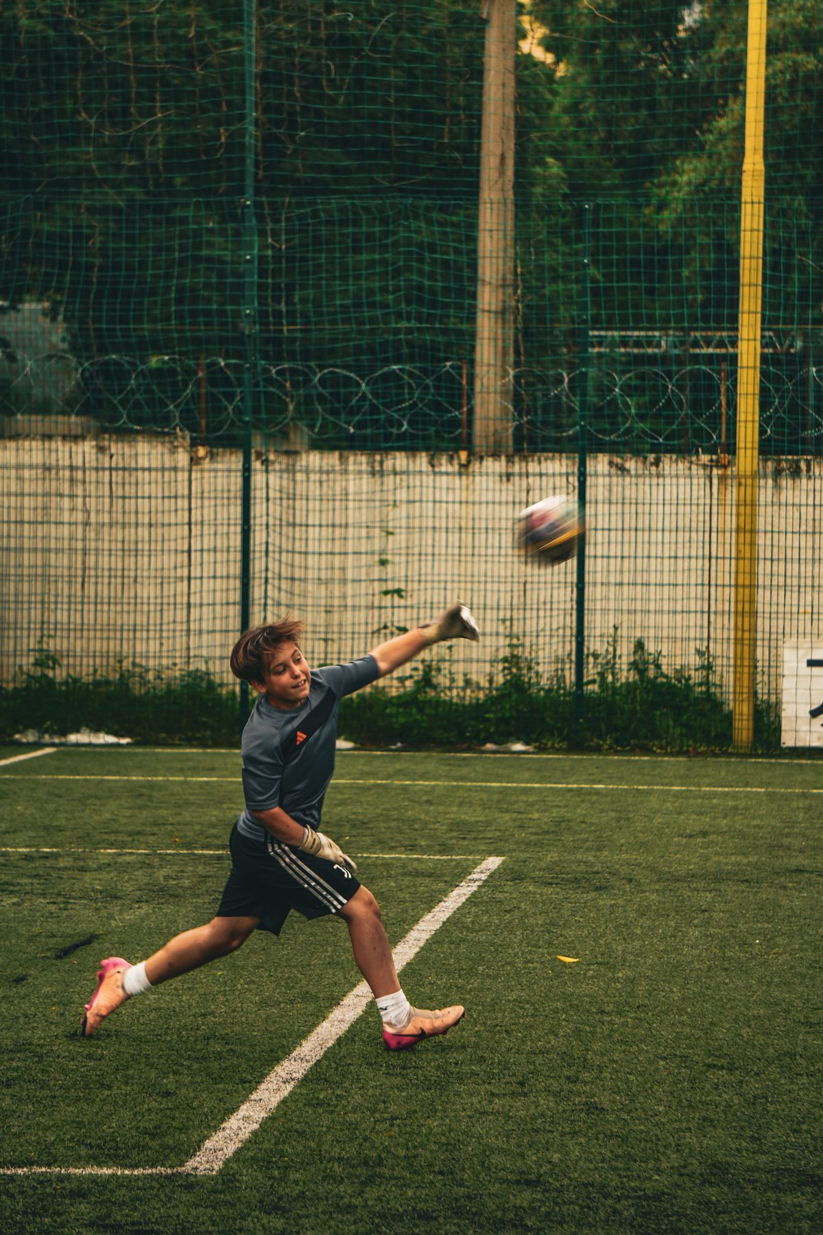 Young goalkeeper training with football coach
