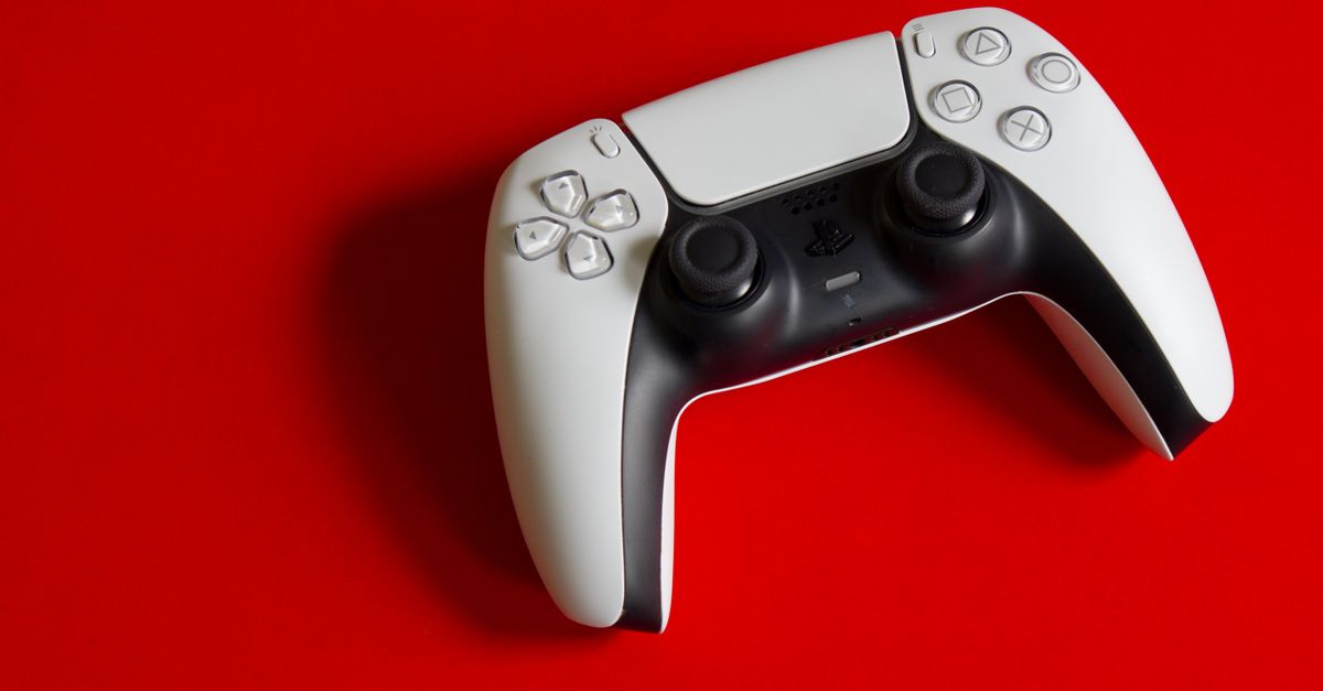 White DualSense controller for PlayStation 5 on a striking red backdrop, emphasizing modern gaming technology.