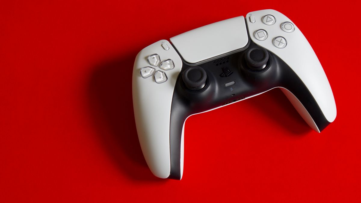 White PlayStation 5 DualSense controller against a bright red background, illustrative photo for GTA 6 age rating coverage
