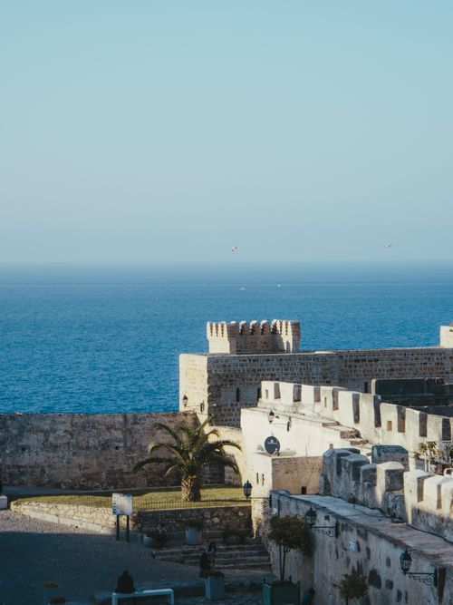 Free View of a historic fortress with ocean backdrop in Tangier, Morocco under a clear blue sky. Stock Photo