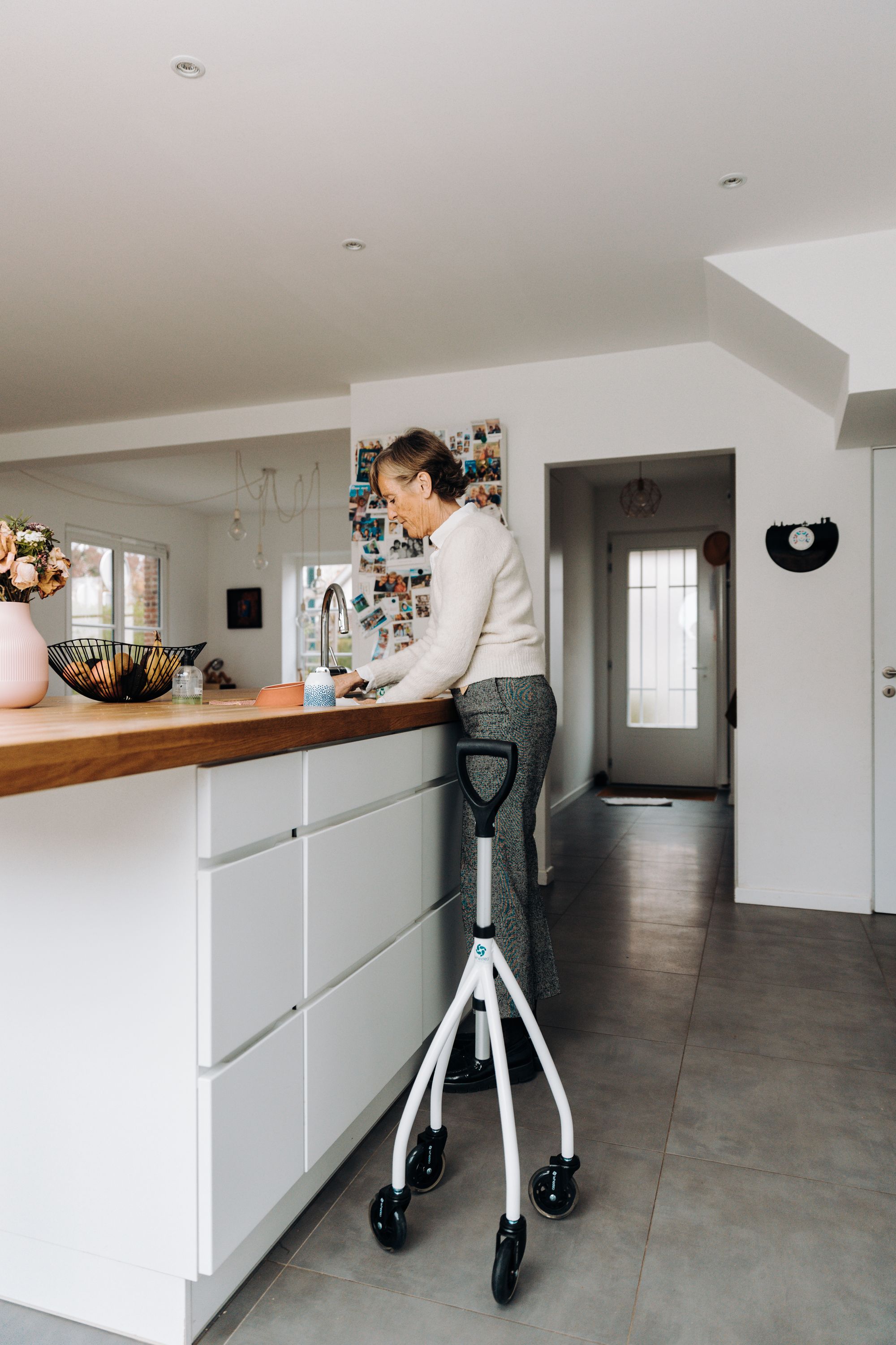 Senior woman using a mobility aid during an everyday home routine in a bright modern setting