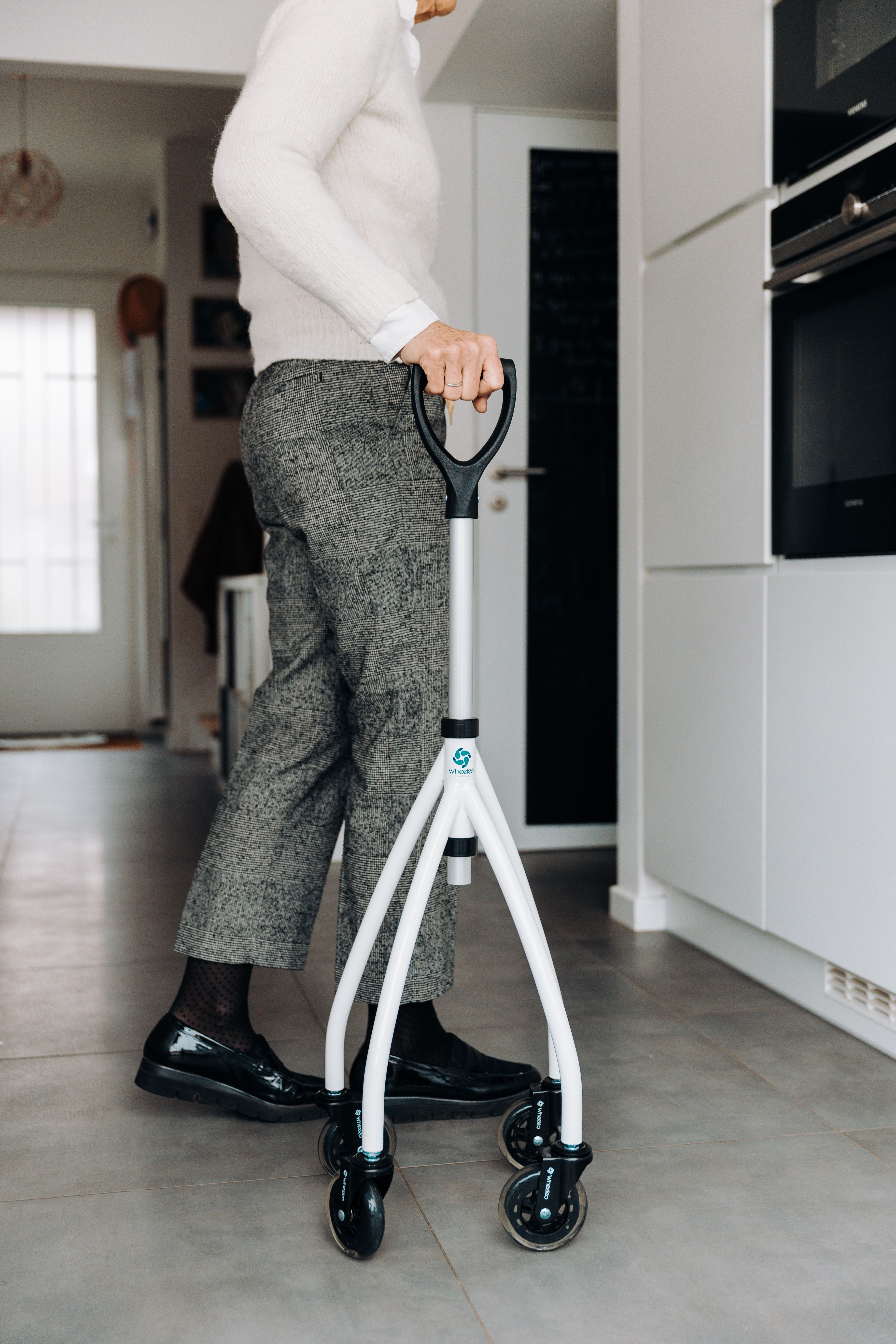 Senior using a walker in a modern kitchen · Free Stock Photo