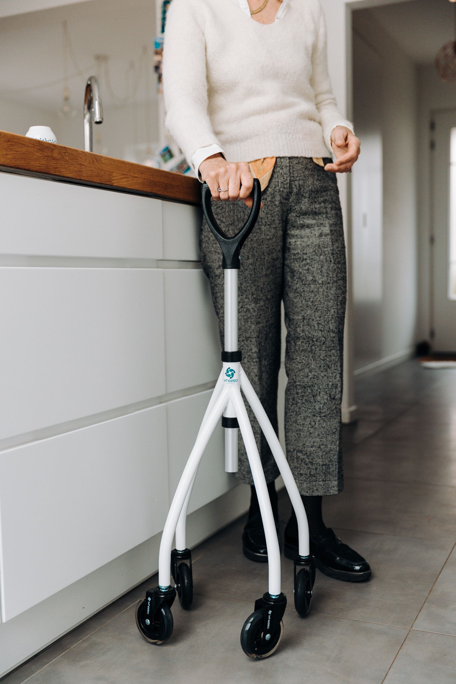 Senior adult using a mobility aid in a modern kitchen
