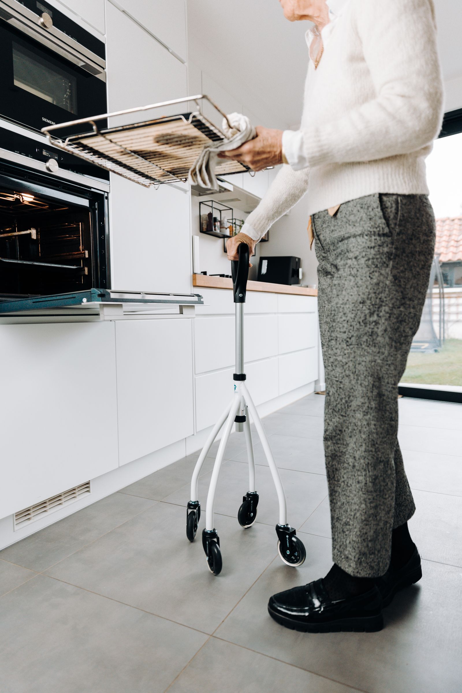 Senior adult baking with a mobility aid in a kitchen