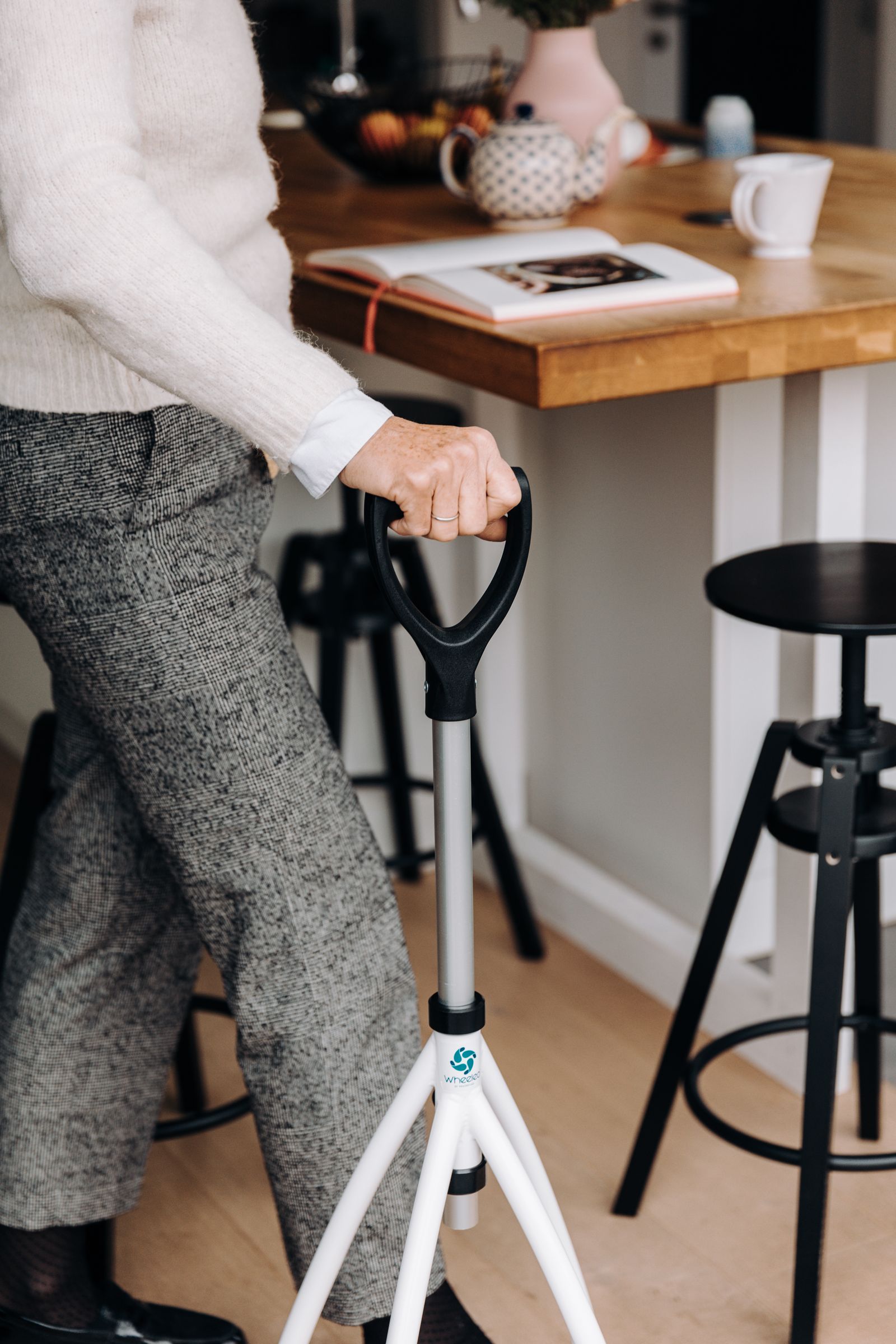 Senior adult with a walking cane in a modern kitchen