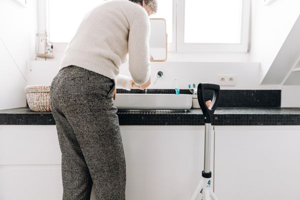 A senior adult washing hands in a modern bathroom, emphasizing hygiene and independence.