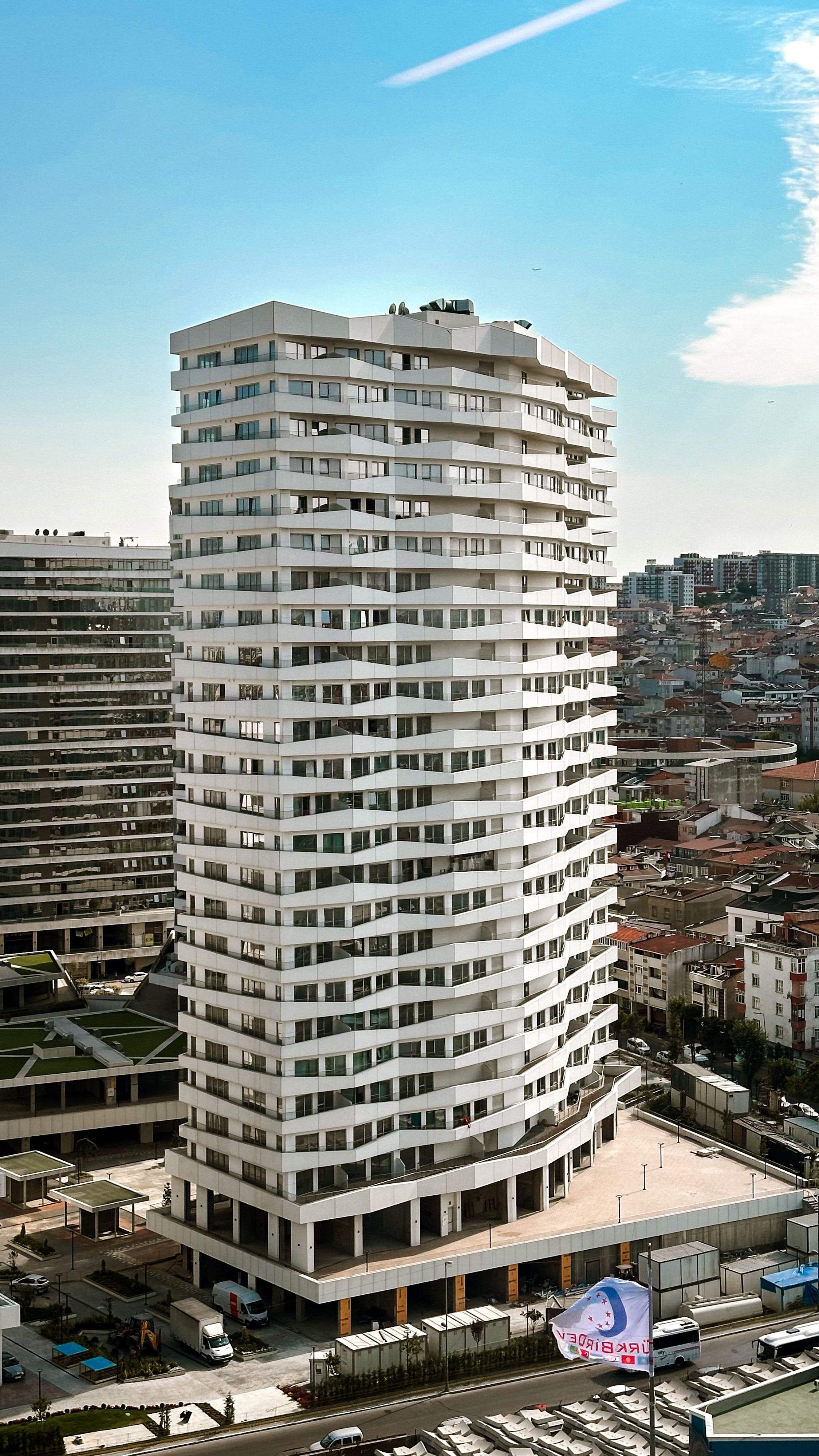 Aerial view of a modern high-rise building in a densely populated urban area.