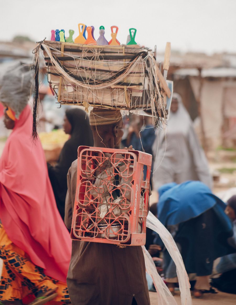 Market trader at a stall, photo by Abubakar Mamuda on Pexels