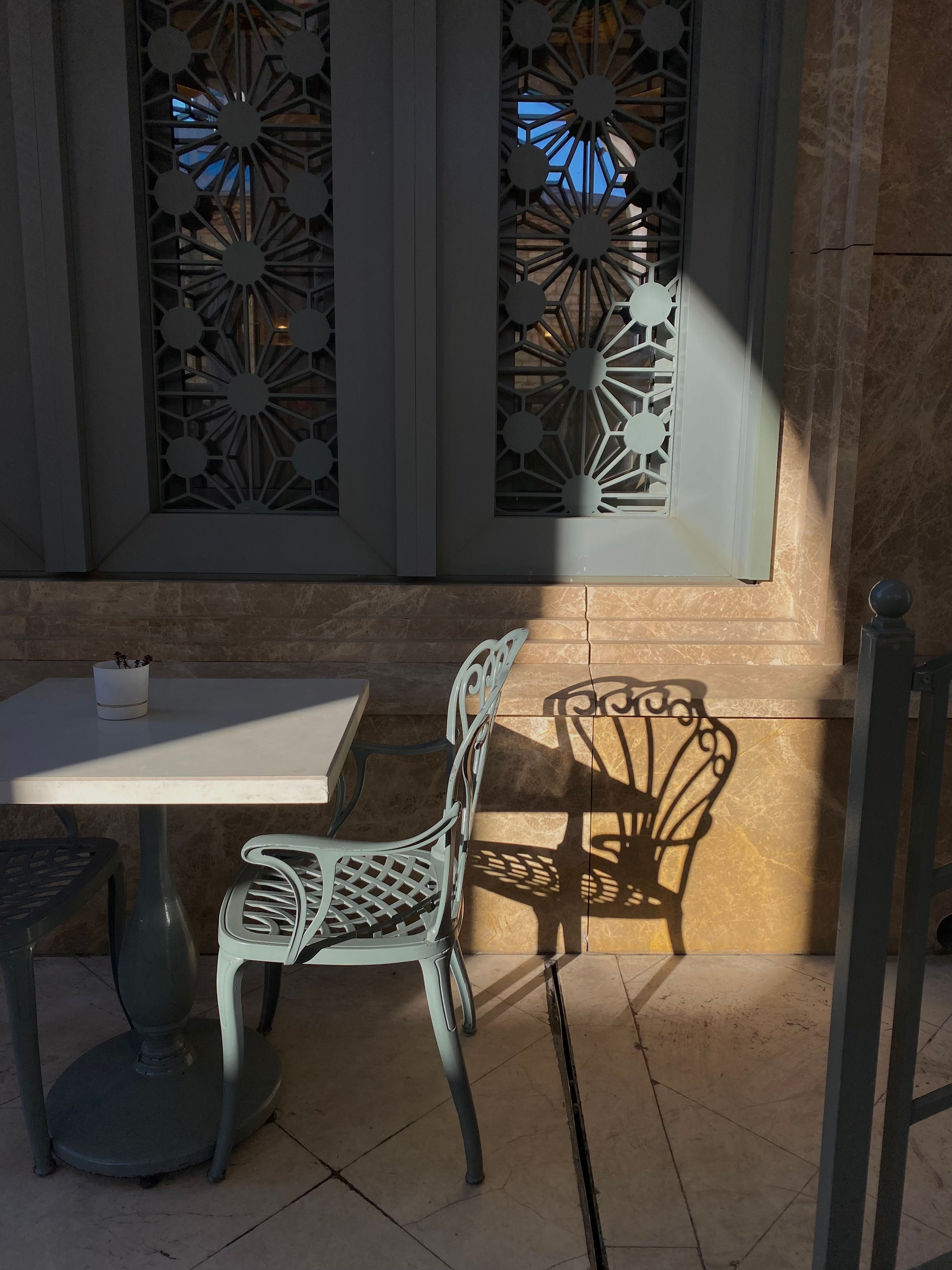 Stylish Outdoor Cafe Table and Chair in Sunlight · Free Stock Photo