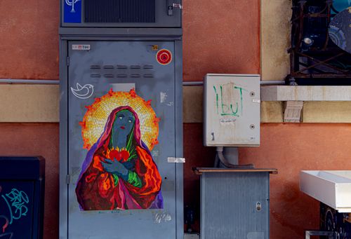Free Colorful mural of a woman with halo on a utility box outdoors in Ravenna, Italy. Stock Photo