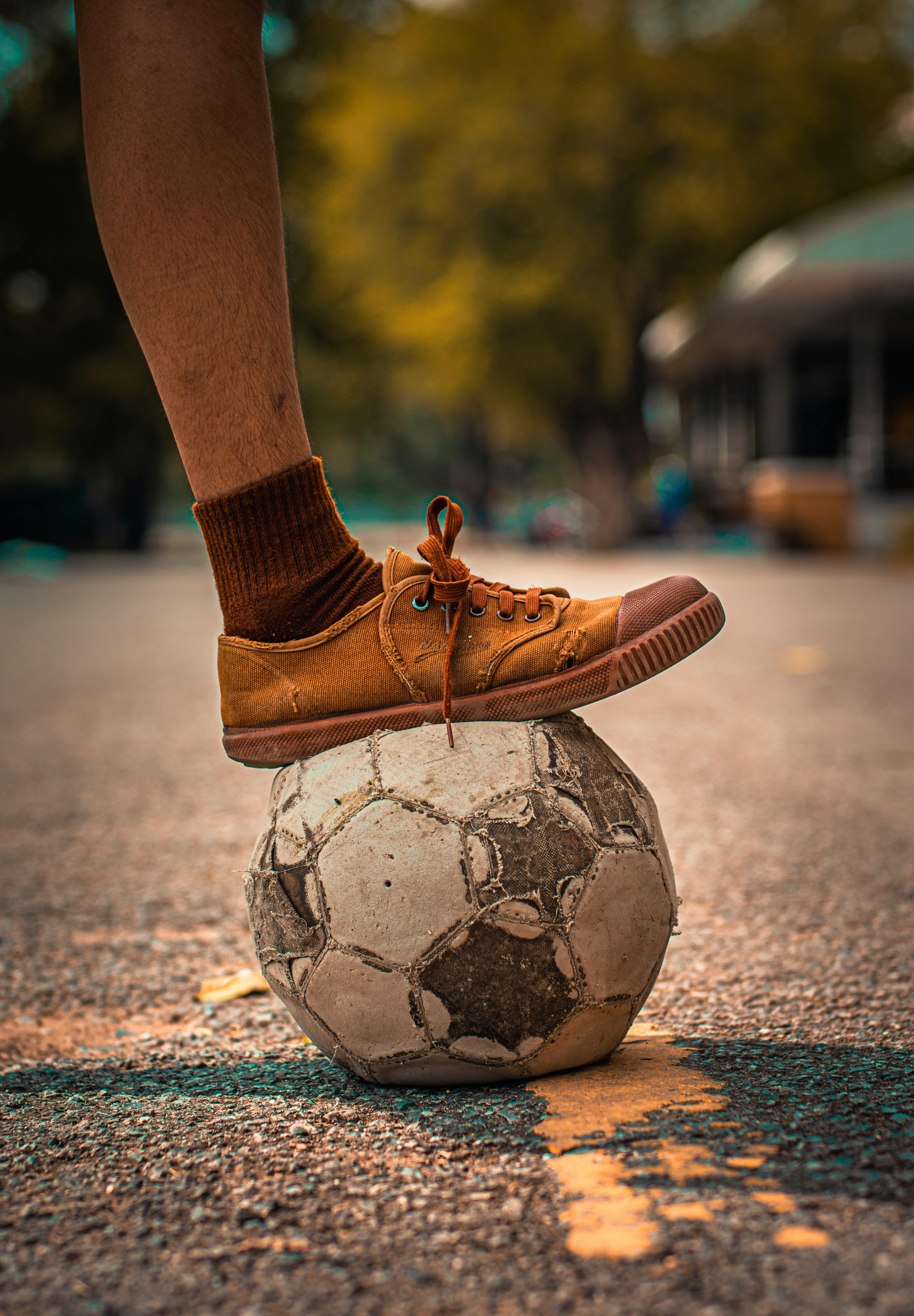 person stepping on a soccer ball