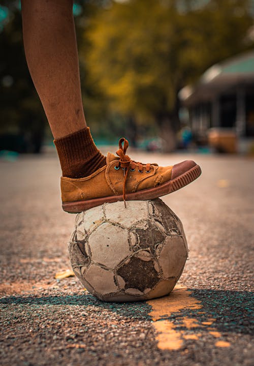 Person Stepping on a Soccer Ball