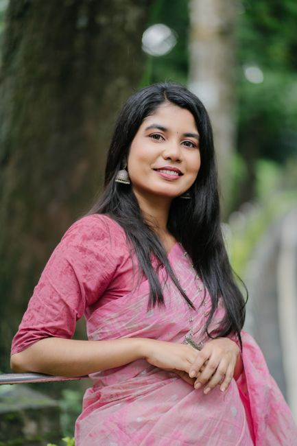 Portrait of a smiling woman in a pink sari with natural background.