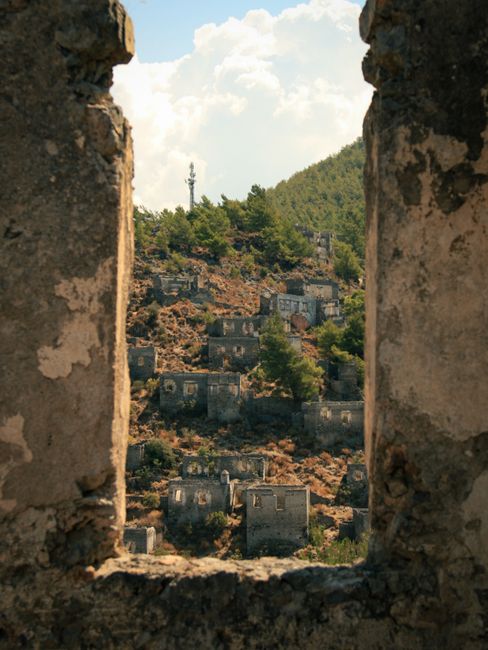 Scenic view of historic abandoned village through stone frame in Kayaköy, Muğla, Türkiye.