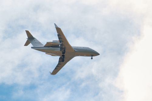 Free A passenger jet flying against a dramatic cloudy sky, showcasing modern air travel. Stock Photo