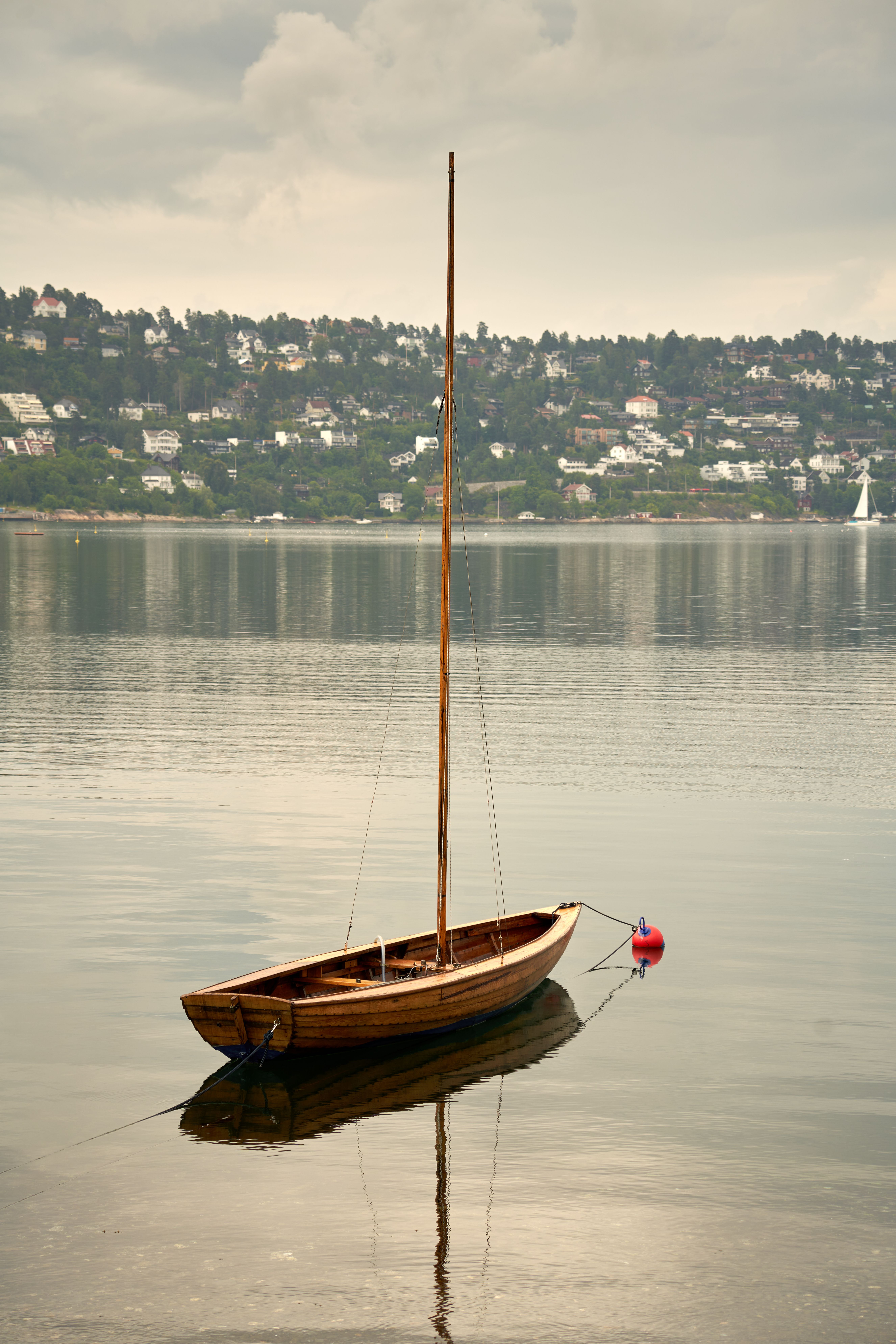 A picturesque traditional wooden boat on Oslo Fjord with scenic coastal views.