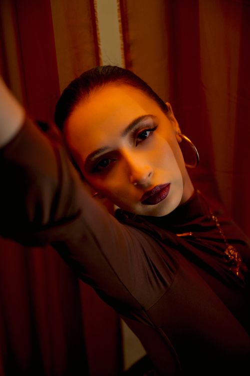 Free Close-up portrait of a woman with dramatic makeup, in rich warm lighting. Stock Photo