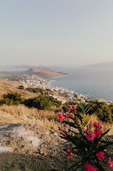 Panoramic sunset view of Sarandë's coastline from Lekursi Castle with Mediterranean Sea backdrop.