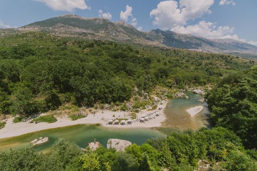 Tranquil view of a clear river and rugged mountains in Albania.