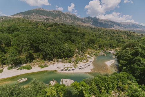 Free Tranquil view of a clear river and rugged mountains in Albania. Stock Photo