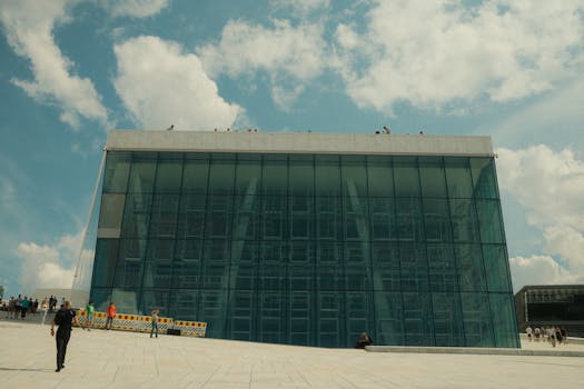 Oslo Opera House glass facade with people enjoying a sunny day.