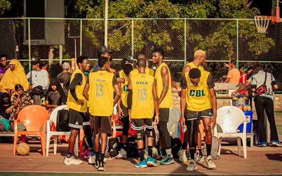 Basketball team huddling on an outdoor court, preparing for a game under the sunny sky.