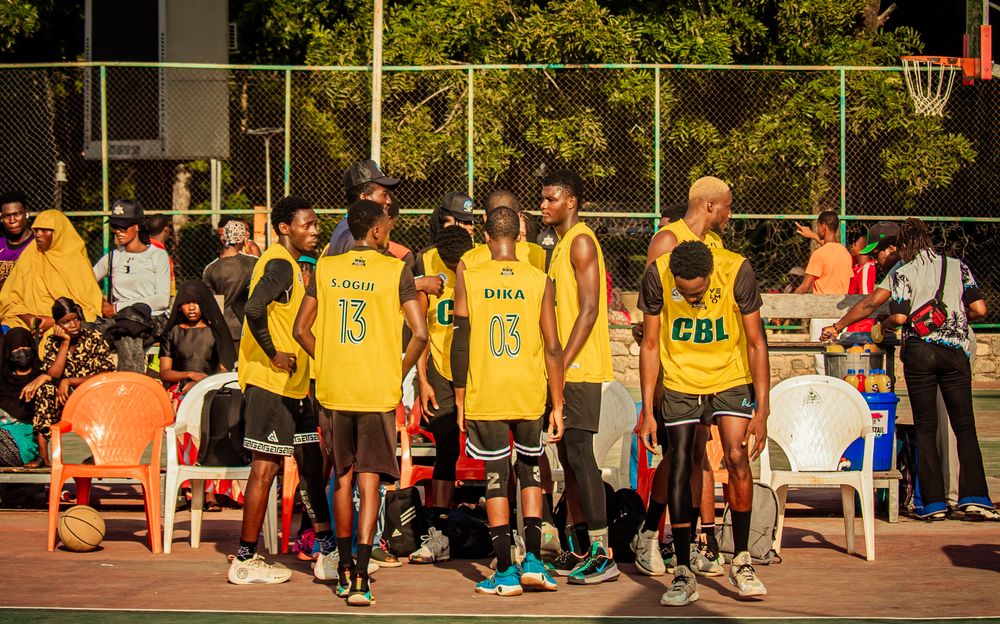 Basketball players in yellow team jerseys beside a court