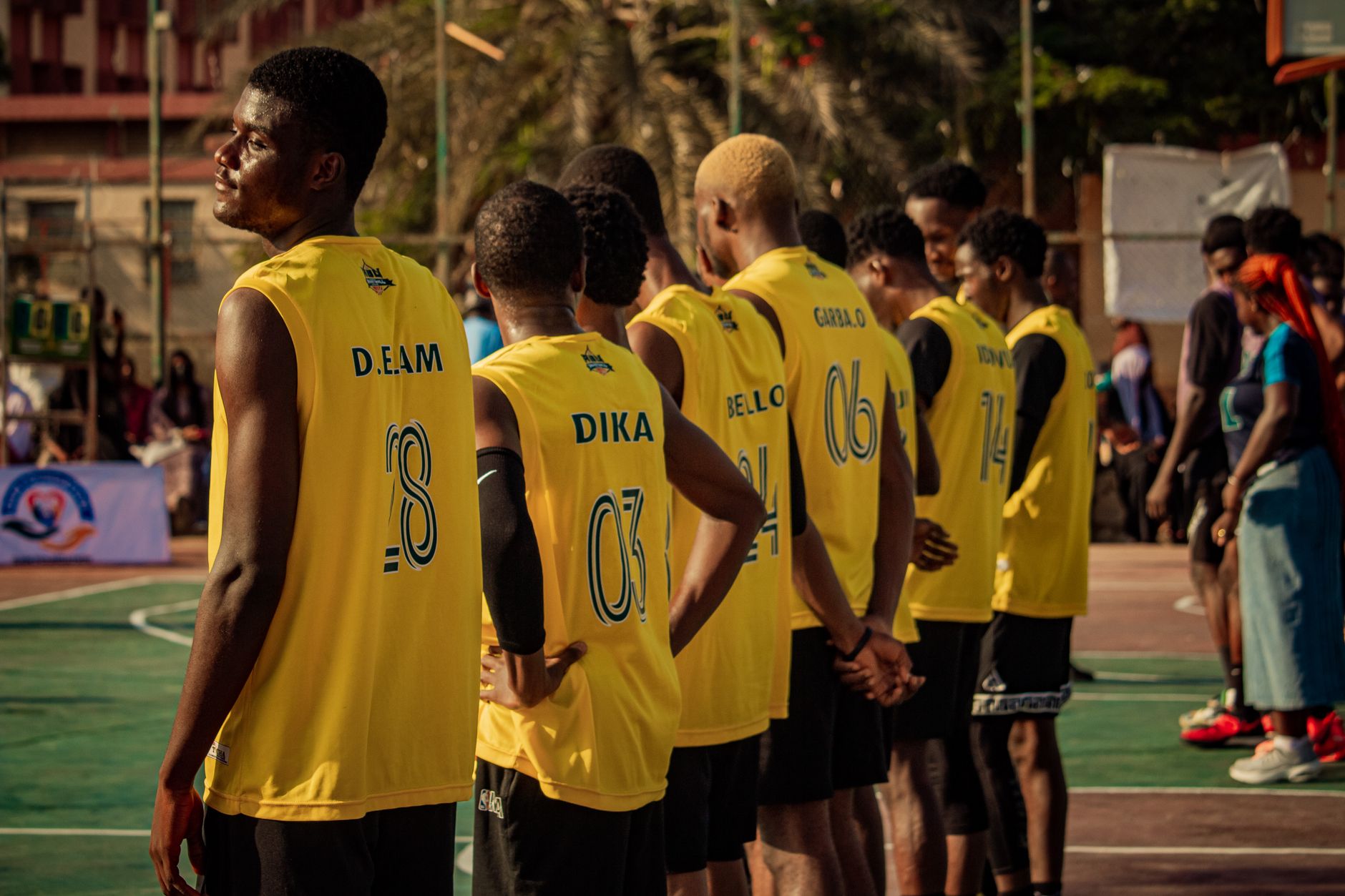 A basketball team stands together on an outdoor court, ready for a game.