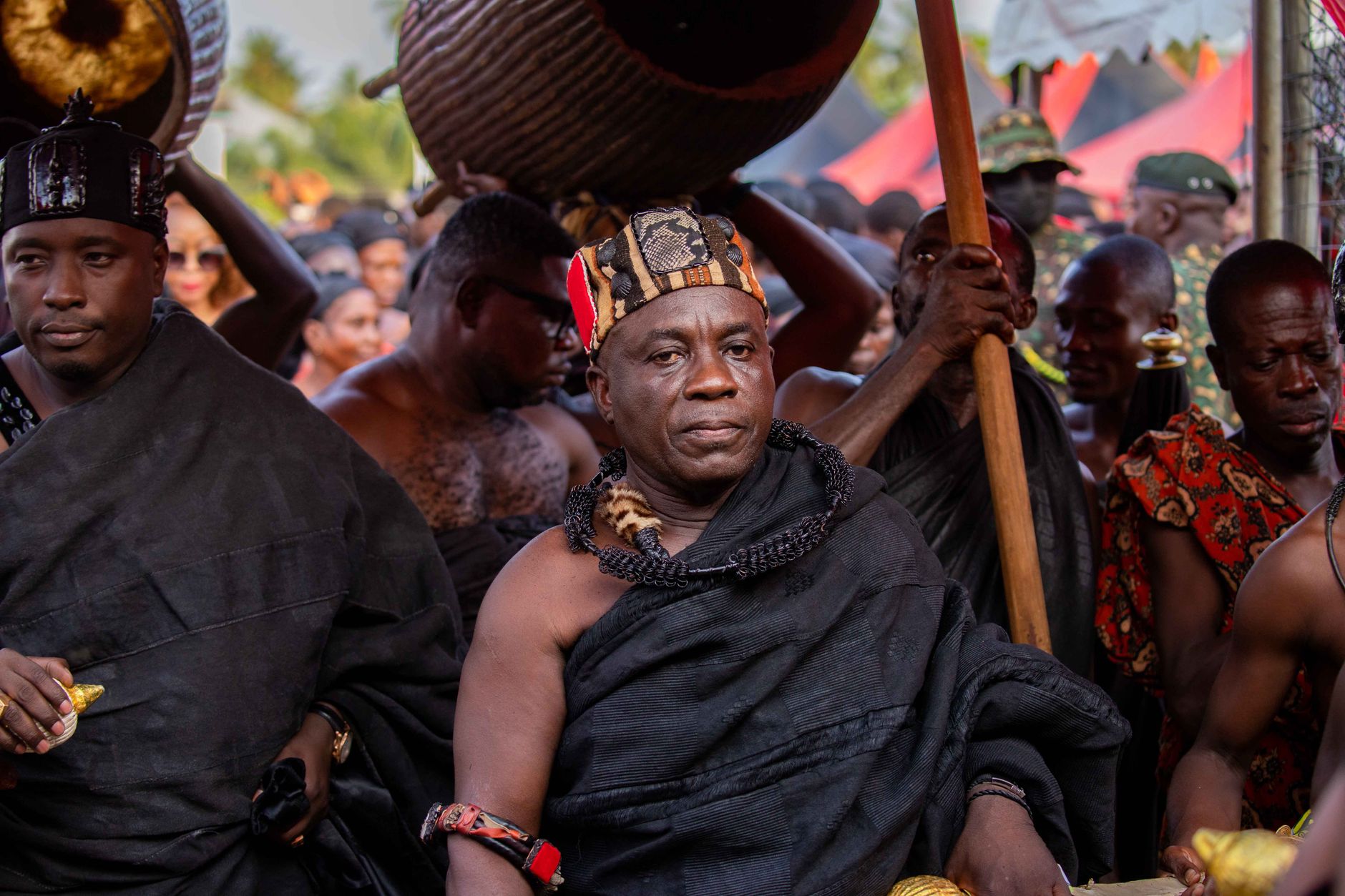 Vibrant traditional ceremony featuring men in cultural African attire, emphasizing rich heritage.