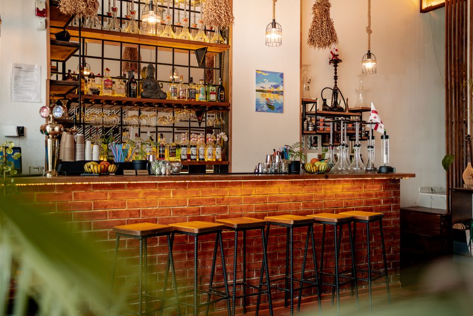 Cozy interior of a neighborhood bar with warm lighting and wooden accents - drink spots near me Cozy interior of a neighborhood bar with warm lighting and wooden accents - drink spots near me