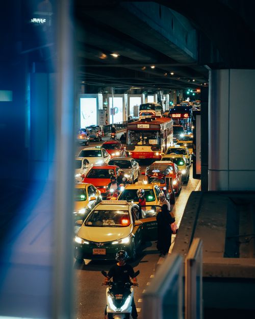 Free A vibrant night scene of a traffic jam under a bridge in Krung Thep Maha Nakhon, Thailand, showcasing buses, taxis, and motorbikes. Stock Photo