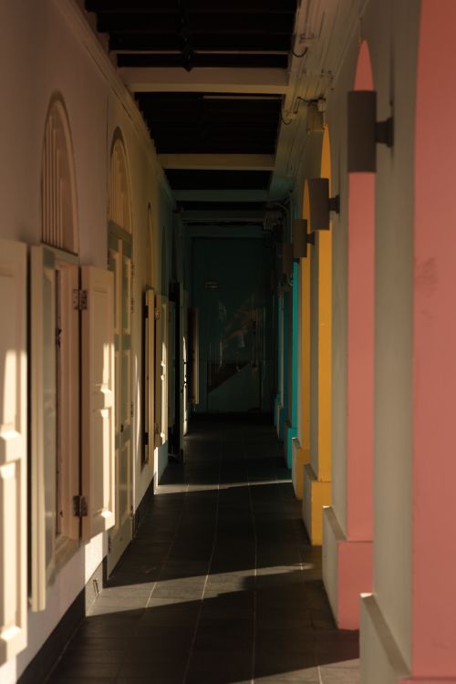 Free A vibrant corridor with colorful colonial arches in sunlight creating a dramatic effect. Stock Photo