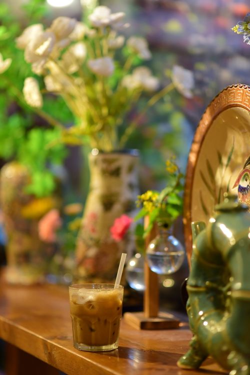 Free Charming café interior with iced coffee, decorative vases, and flowers creating a warm, rustic atmosphere. Stock Photo