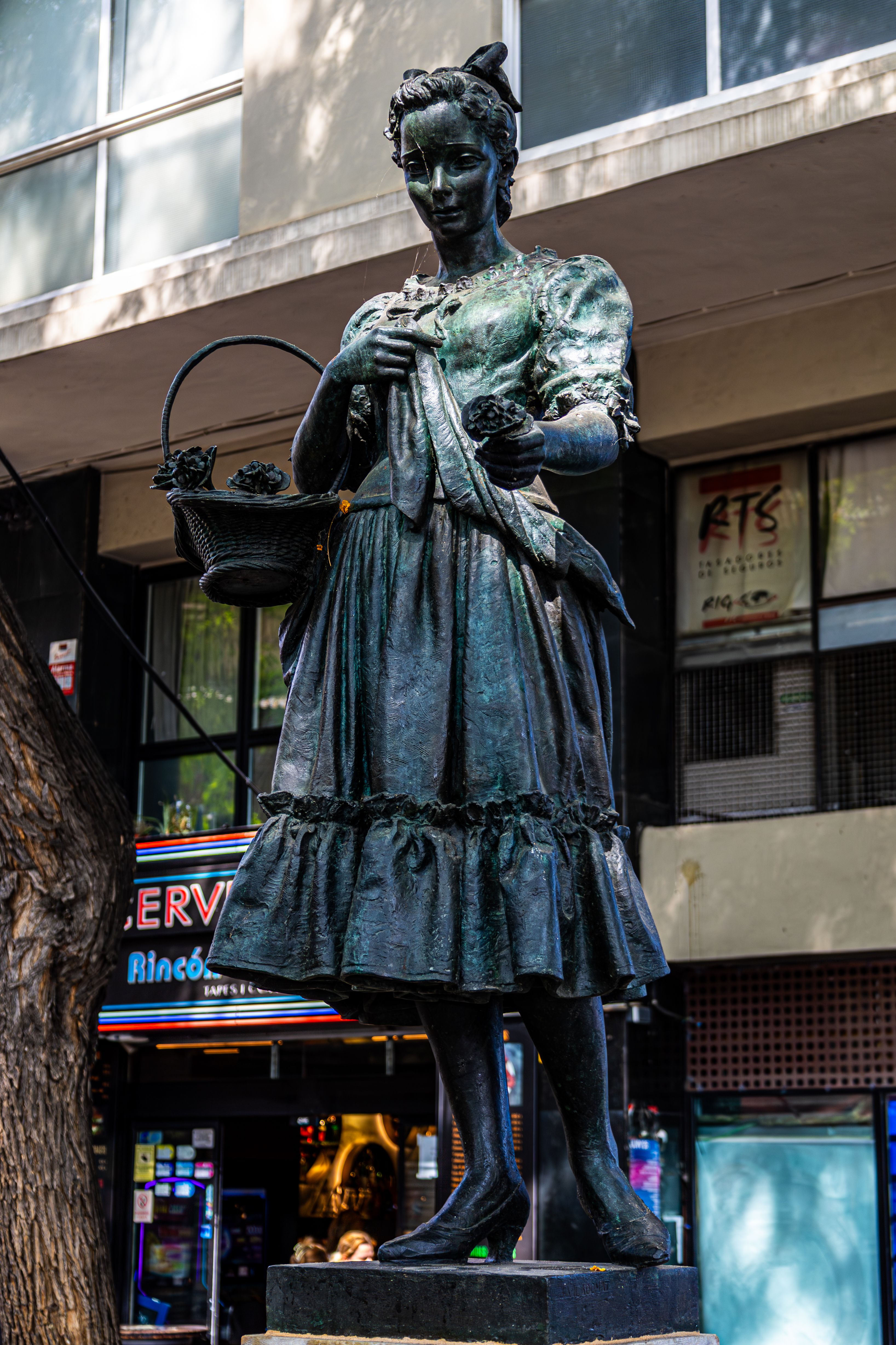 Bronze statue depicting a woman in traditional attire located in Barcelona, Spain.