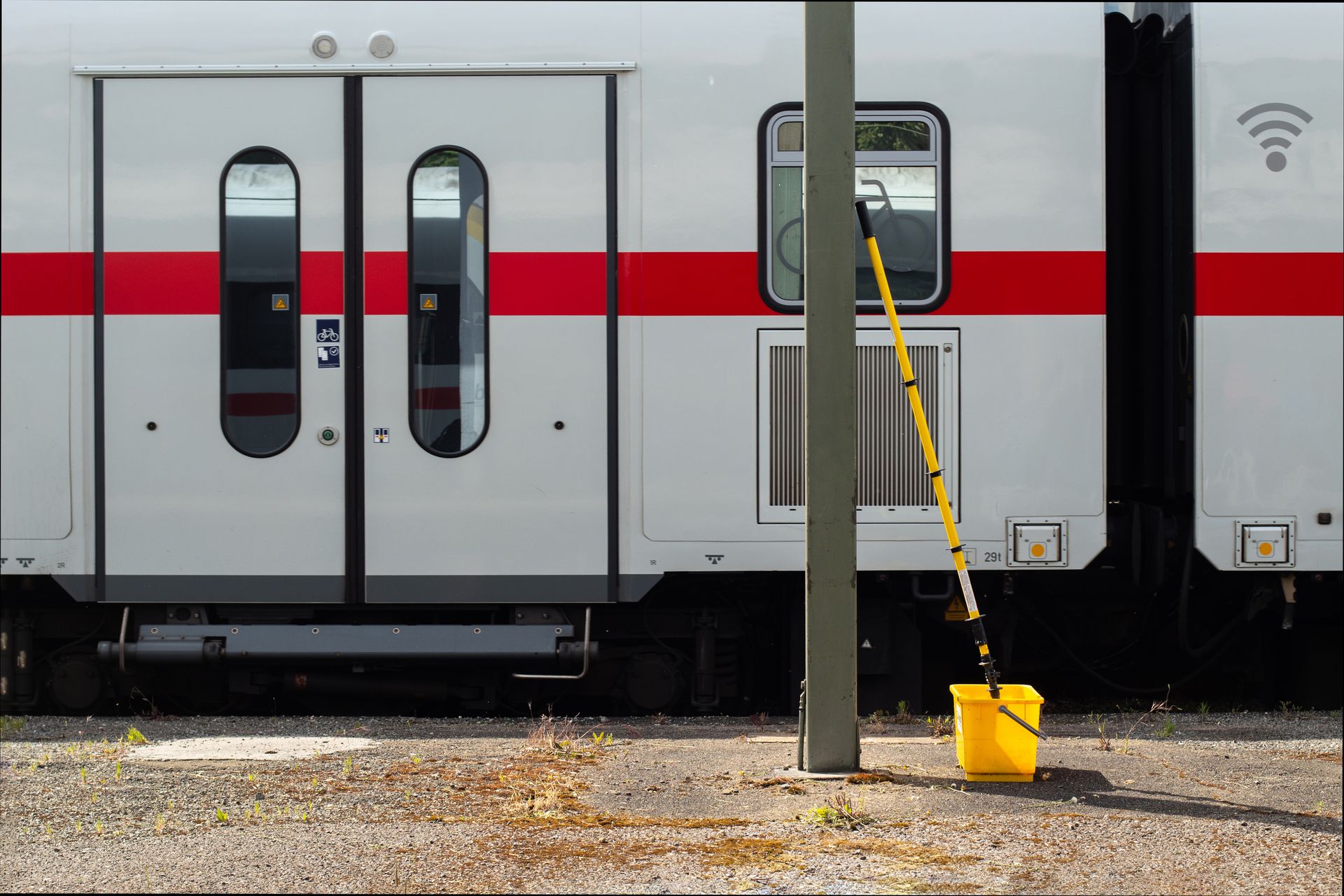Image of a modern train with cleaning equipment on standby outside.