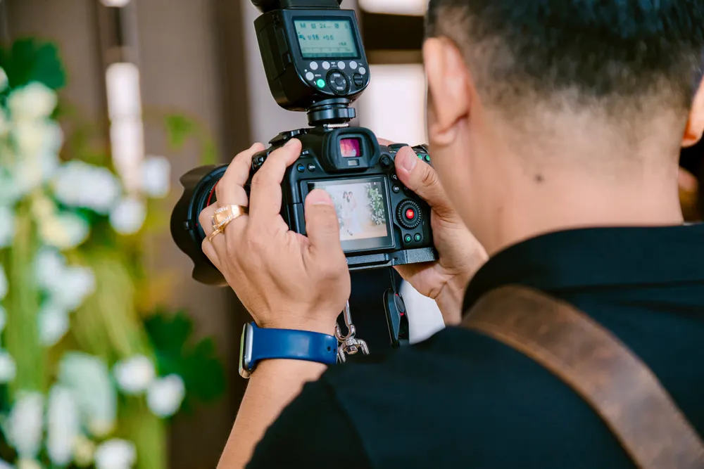 Photographe de mariage cadrant au reflex