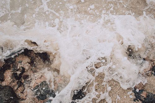 Free Close-up of a wave crashing on rocks, showcasing water texture and motion. Stock Photo