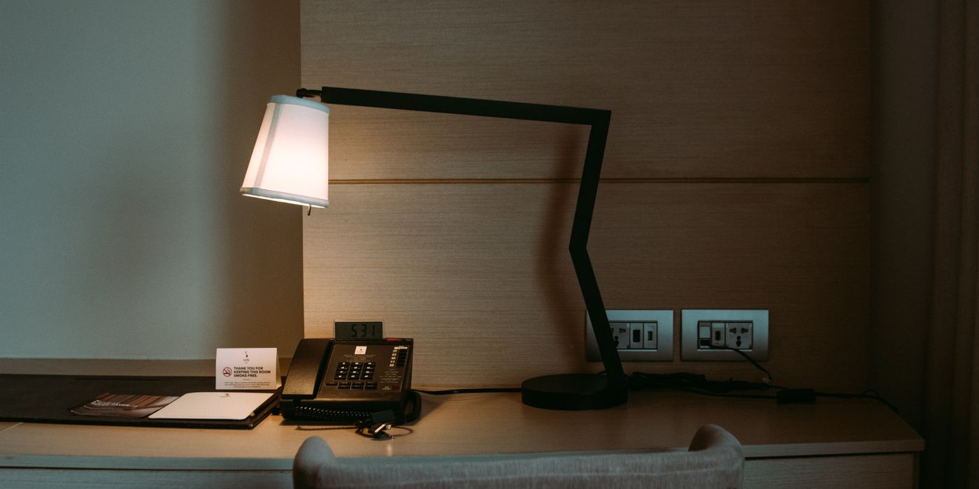 Modern hotel room desk with a lamp, telephone and stationery set
