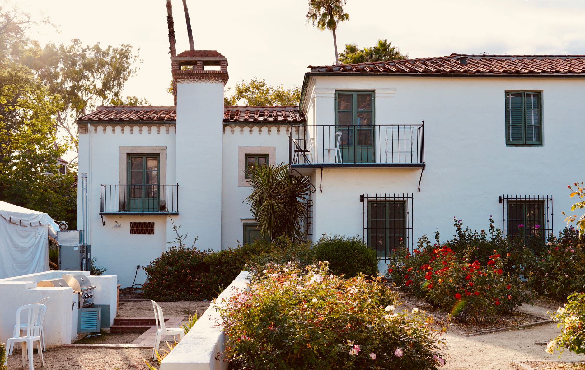 Spanish Colonial home with a garden and tile roof in bright sun — exterior paint colors for San Diego homes