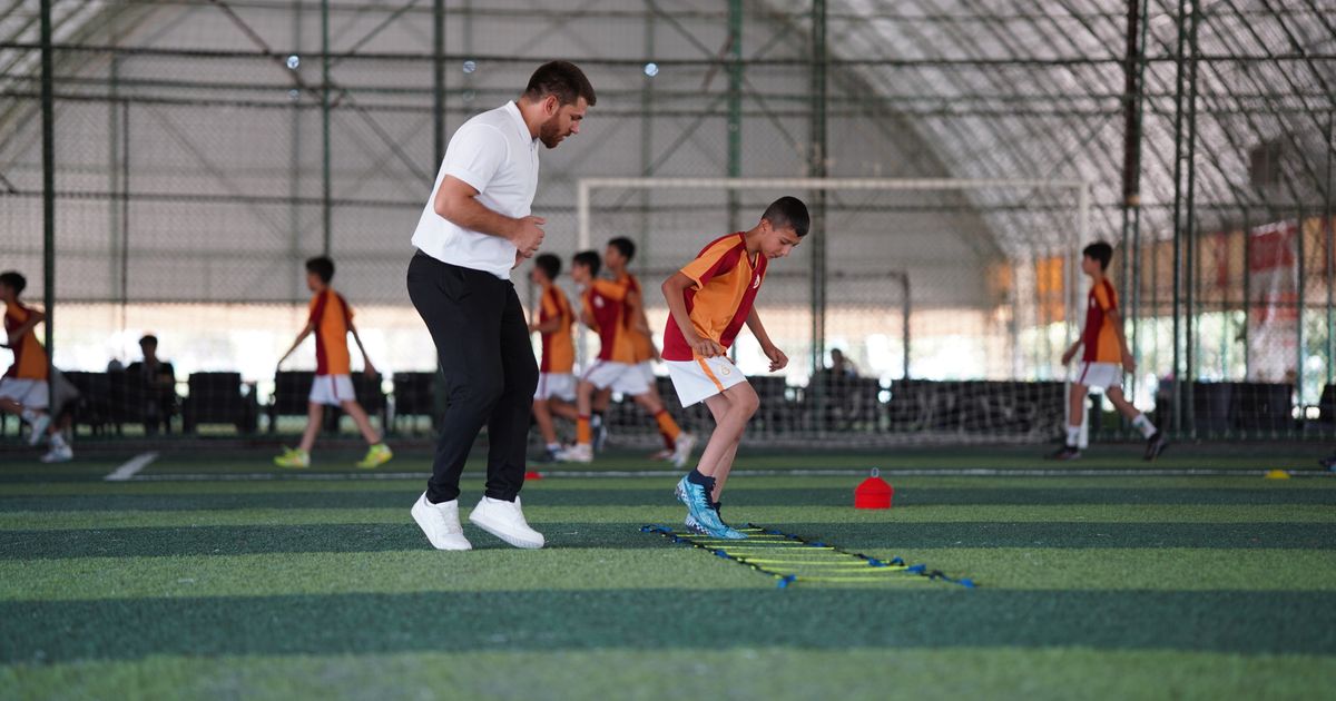 A retired athlete mentoring a young coach in a sports facility.