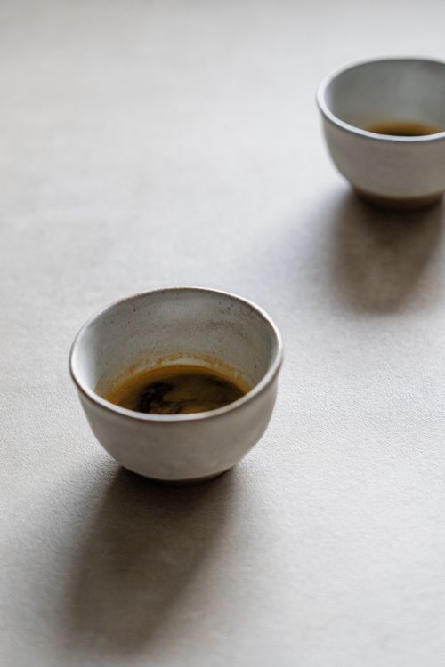 Free Two ceramic cups with coffee on a light-textured surface, creating a serene and minimalist scene. Stock Photo