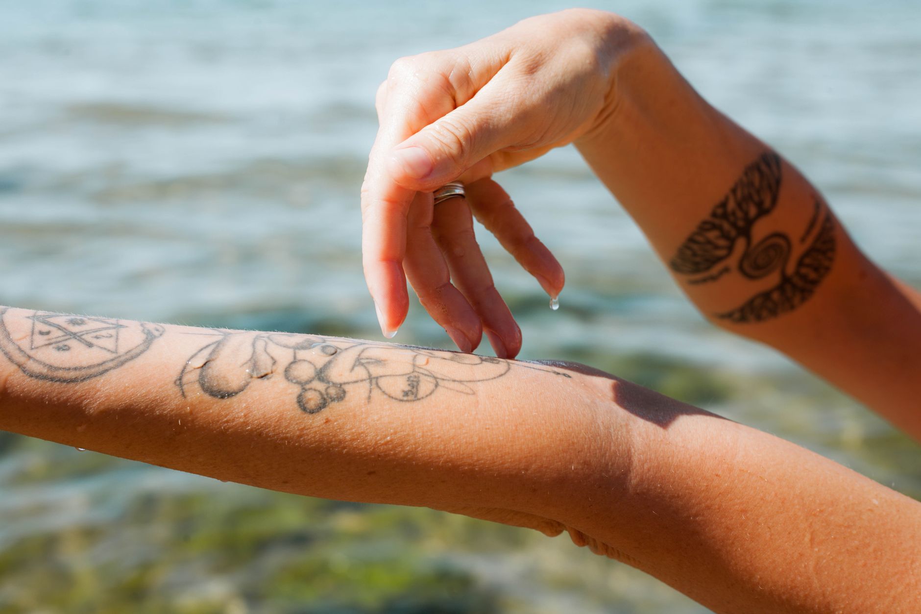 Close-up view of temporary tattoo application process on clean skin with water
