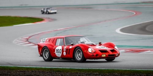 Free Red vintage racing car navigating a track curve during a race. Stock Photo