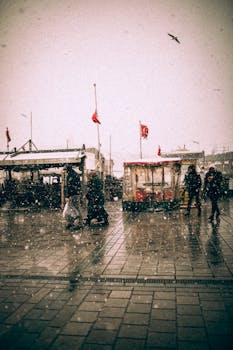 Capture of a bustling İstanbul street during a snowstorm, highlighting the city's lively atmosphere.