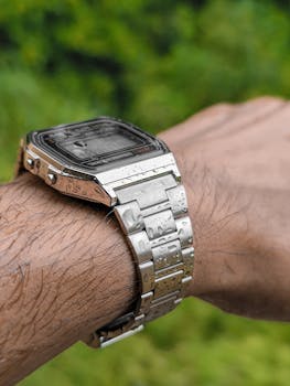 Close-up view of a water-resistant watch on a wrist with rain droplets, showcasing modern retro design.