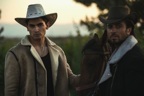 Free Two cowboys with a horse during sunset in a Western style scene. Stock Photo