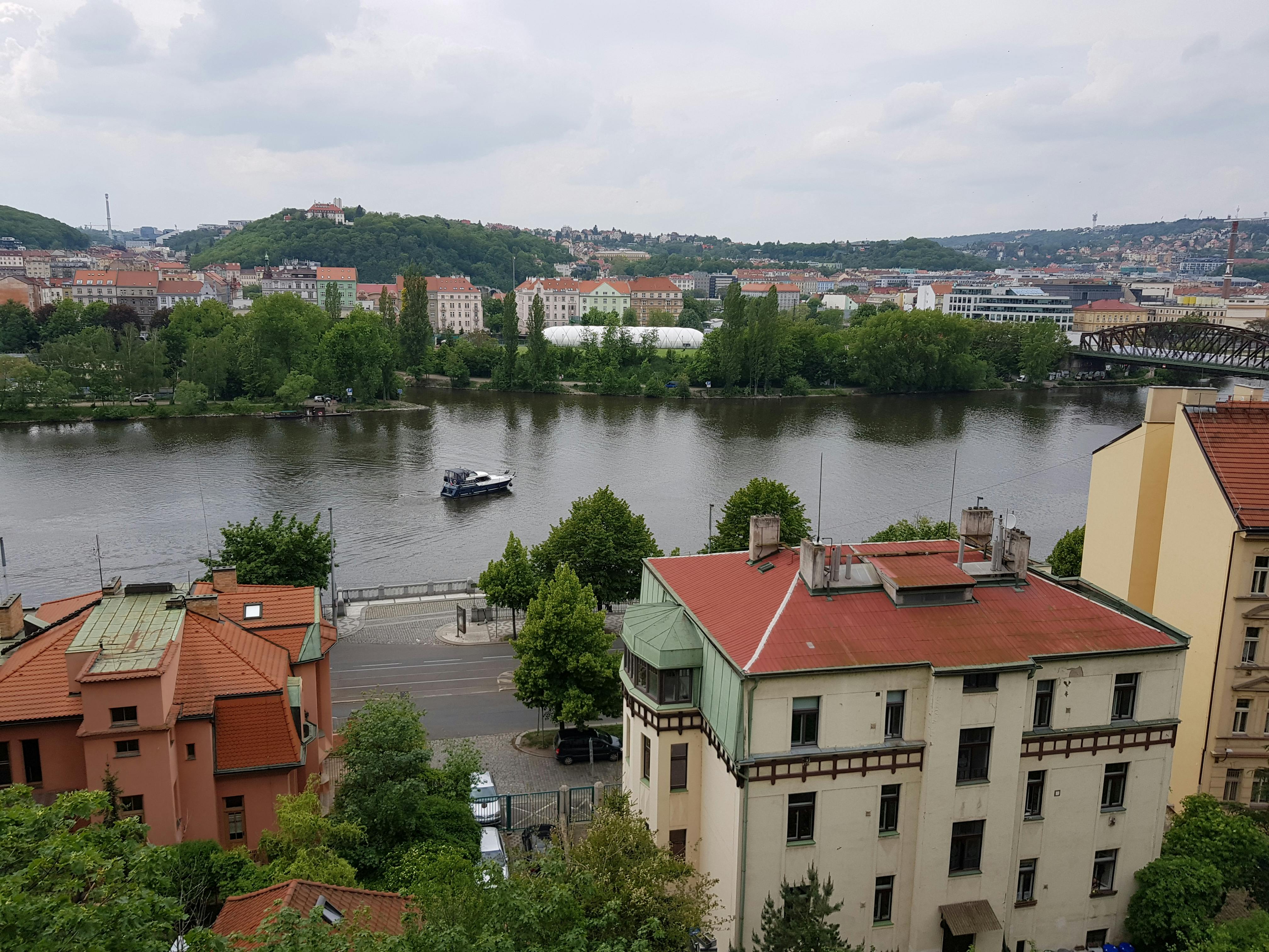 A panoramic view of Prague with the Vltava River and historic buildings in the background.